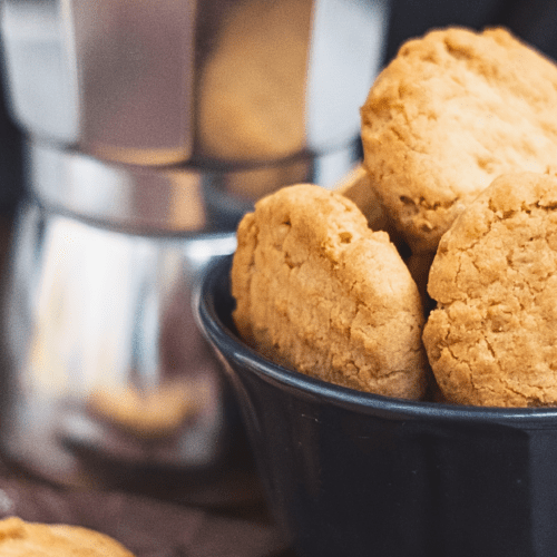 A black bowl with freshly baked peanut butter cookies